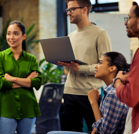 A group of young professionals gathered around and listening to someone offscreen